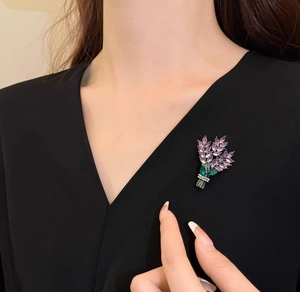 Détail d'une élégante broche lavande en cristal épinglée sur un vêtement noir