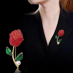 Spilla a rosa di lusso con strass rossi, foglie smaltate verdi e dettaglio di perla