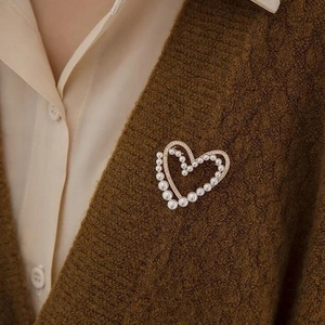 Broche cœur double couche en or avec perles et zircons sur un cardigan marron chic