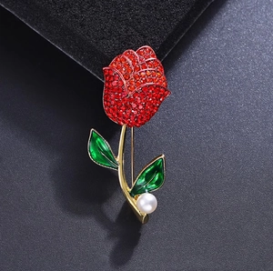 Lussuosa spilla a rosa con cristalli rossi, foglie in smalto verde e perla bianca