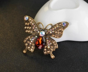 Detailansicht der Vintage-Schmetterlingsbrosche mit Strass und rotem Tropfen-Edelstein