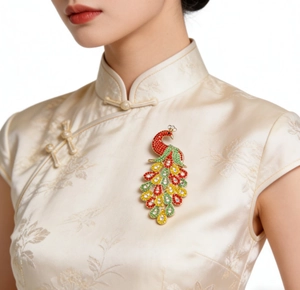 Detail of elegant peacock brooch with colorful rhinestones on silk dress