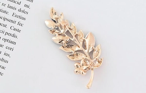 Detailed view of the golden metal flower brooch back showing the pin safety clasp mechanism