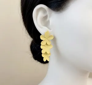 Eleganti orecchini a fiore giallo a tre strati con finitura opaca sull'orecchio del modello