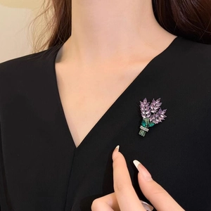 Élégante broche lavande avec cristaux violets épinglée sur un vêtement noir à col en V