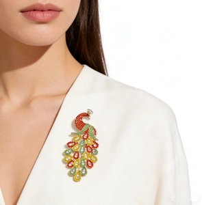 Detailed view of peacock brooch with colorful rhinestones on white blazer lapel