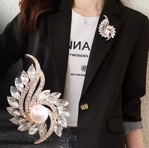 Elegant floral brooch with center pearl and radiating marquise crystals in rose gold finish