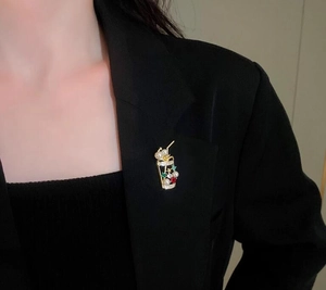 Detail of a pearl and rhinestone beverage cup brooch on a black suit lapel