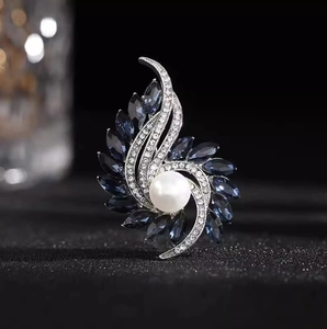 Elegant silver flower brooch with deep blue crystals and a large white pearl center