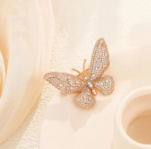 Macro detail of rose gold butterfly brooch featuring micro-set sparkling white zircon stones