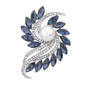 Detailed view of flower brooch with blue marquise crystals and a large white pearl