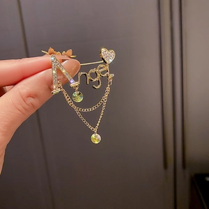 Gros plan d'une broche Angel dorée avec des strass étincelants et des pompons en cristal