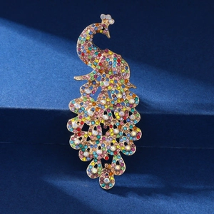 Detailed close-up of a golden peacock brooch with vibrant multicolored rhinestone inlay