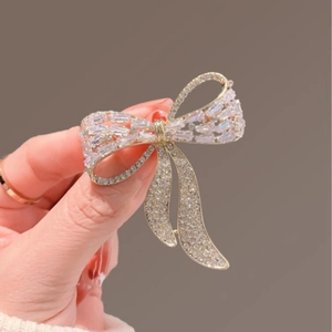 Elegant gold bow brooch with sparkling white cubic zirconia crystals for women