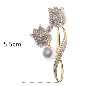 Détail d'une broche tulipe dorée de 5,5 cm avec des strass blancs et une perle nacrée