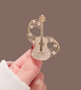 Vue macro détaillée de la broche guitare dorée sertie de cristaux étincelants