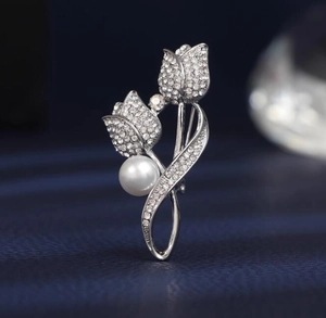 Vue rapprochée d'une broche tulipe avec des strass brillants et une perle blanche