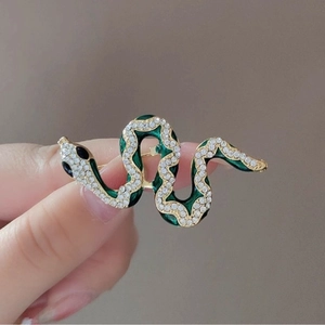 Elegant snake brooch with green enamel and white crystals in gold plating for suits