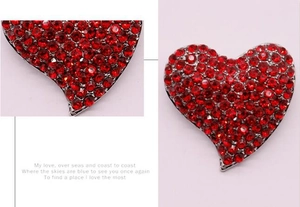 Vue détaillée de la broche cœur rouge montrant les strass brillants et la base en alliage