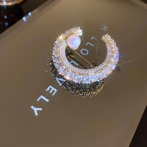 Élégante broche en forme de lune avec cristaux brillants et perle blanche sur fond miroir