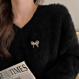 Elegante broche de lazo dorado con cristales brillantes en jersey de terciopelo