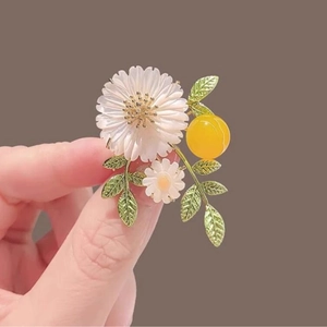 Daisy flower brooch with white petals, yellow bead, and green leaves for women