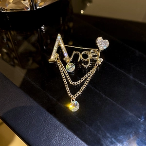 Détail de la broche Angel avec diamants scintillants et glands en cristal suspendus