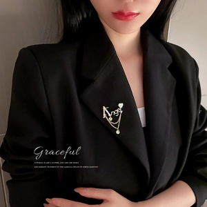 Broche Angel élégante en métal doré avec strass et pierre goutte verte sur costume