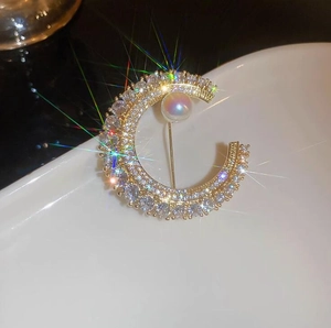 Élégante broche lune dorée avec cristaux scintillants et une perle blanche éclatante