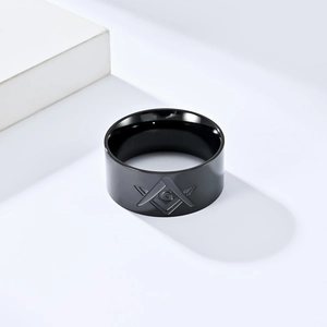 Detalle de anillo masónico negro de acero inoxidable con símbolo G grabado y escuadra