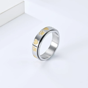 Detailed close-up of spinner ring featuring golden heart and pet paw print patterns