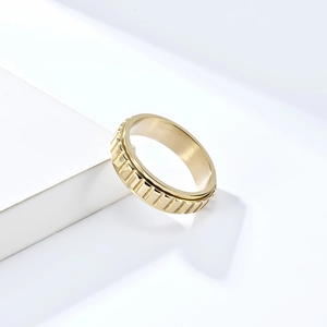 Gros plan détaillé d'une bague rotative en acier titane doré à texture rainurée