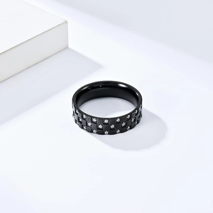 Gros plan d'une bague en acier noir avec motif damier et zircons blancs incrustés