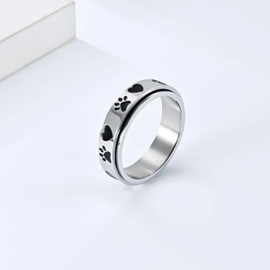 Macro view of rotating spinner ring featuring black paw and heart enamel patterns