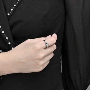 Minimalist silver titanium steel ring with a heart-shaped crystal on a woman's finger