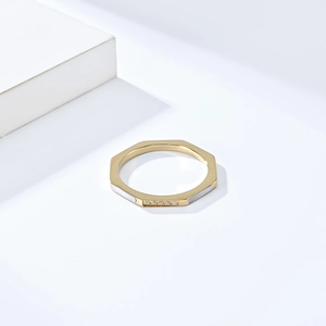 Vue macro d'une bague octogonale dorée avec incrustations en nacre blanche et micro-zircons