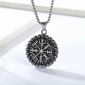 Detailed view of vintage silver Viking compass pendant with engraved Nordic runes on white