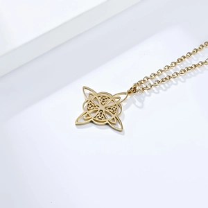 Detail van een gepolijste gouden Keltische knoop hanger met een verfijnd hol ontwerp