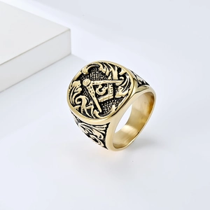 Close-up of vintage gold Freemason ring showing intricate engravings and G symbol