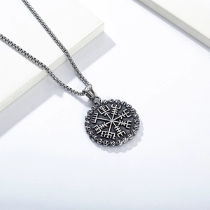 Close-up of vintage Viking compass necklace with Runic alphabet and blackened steel finish