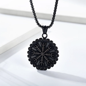 Macro shot of black stainless steel Viking Vegvisir pendant and engraved Nordic Runes