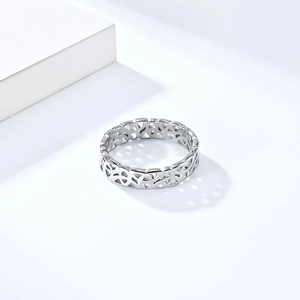 Vue macro d'une bague nœud viking argentée avec ombres sur des cubes blancs minimalistes