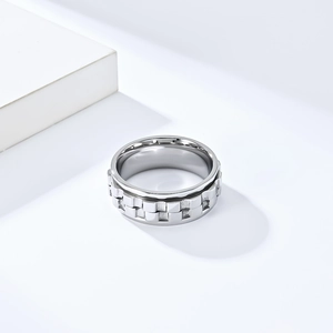 Detailed macro view of silver spinner ring with textured brick patterns and polished inner surface