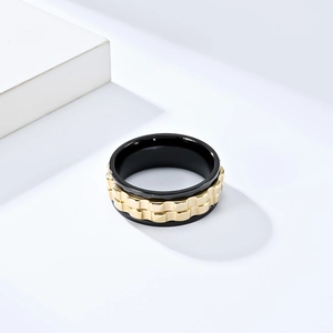 Macro shot of rotatable spinner ring featuring black ceramic edges and golden gear chains