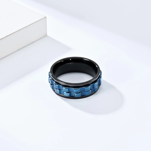 Close-up of rotating blue gear texture on black stainless steel anxiety relief ring