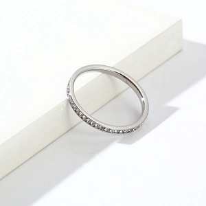 Bague minimaliste 2mm argentée sertie de cristaux brillants sur un support géométrique blanc