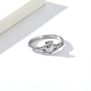 Gros plan d'une bague Claddagh en argent poli montrant les détails de cœur et couronne