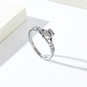 Vue latérale macro d'une bague Claddagh en acier titane argenté sur fond blanc