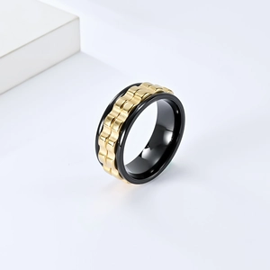 Modern black titanium fidget ring with a rotatable gold watch-band style gear center
