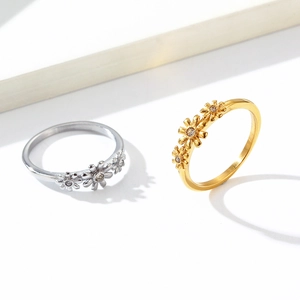 Anillo de margaritas en acero de titanio con tres flores y circón en acabado oro y plata